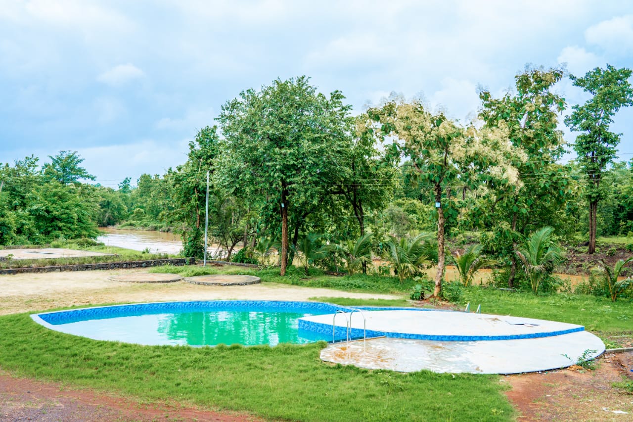 Outdoor pool and lawn at S.K. Agro Tourism & Hotel